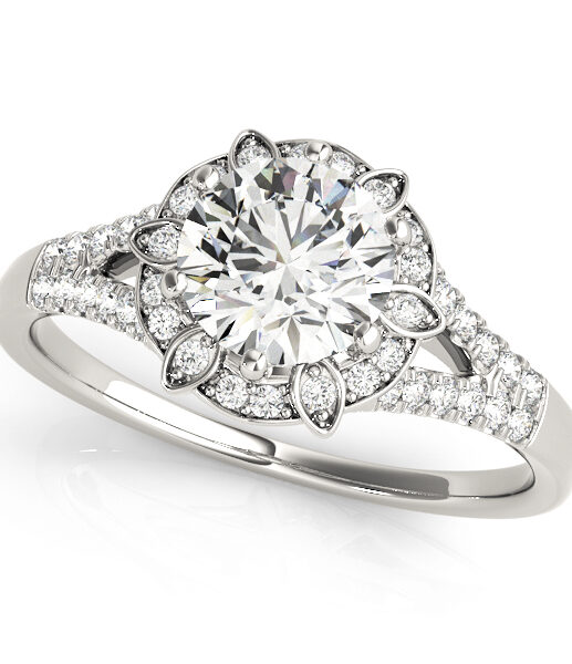 a petite white gold diamond halo engagement ring surrounded by smaller diamonds on each of the split shanks