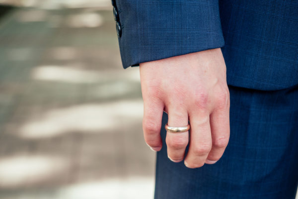 A man wearing a gold wedding ring
