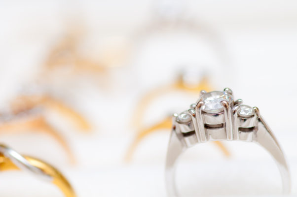 White gold three stone diamond ring focused view among other yellow gold rings