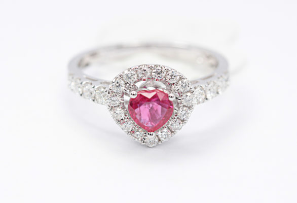 Pink engagement rings design sample of pink ruby held by 3 prongs in white gold metal in a white background