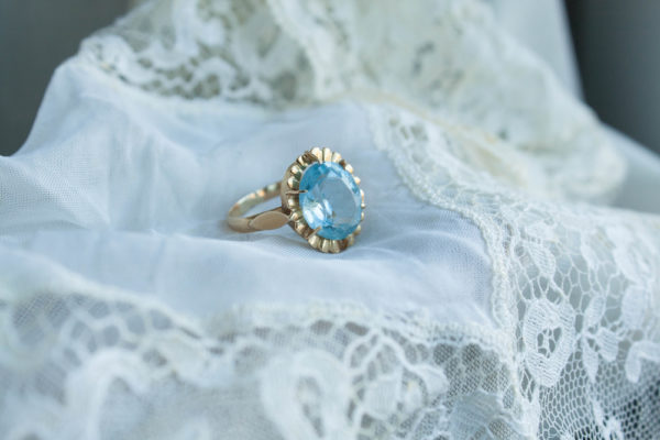 Vintage style engagement rings sample with oval shaped blue sapphire ring placed on white cloth