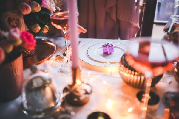 a small box above white plates on Christmas dining table