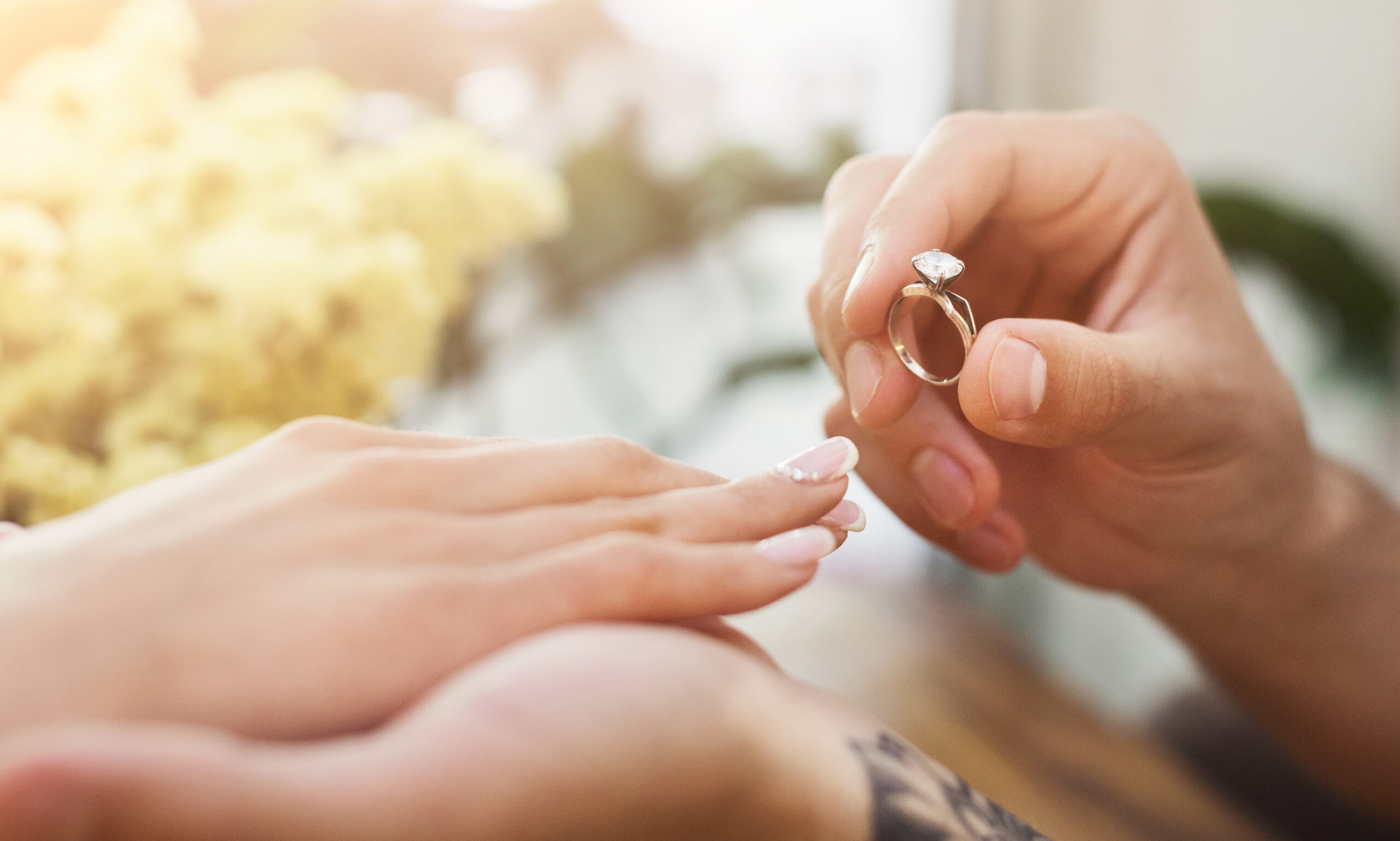 Man putting on girl finger engagement ring